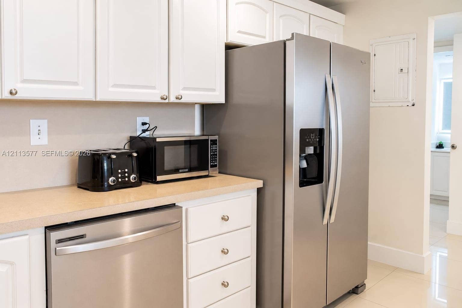 19370 Collins Avenue, #1622, Sunny Isles Beach, FL 33160 Kitchen featuring white cabinetry, neutral-toned countertops, and stainless steel appliances including a side-by-side refrigerator and dishwasher