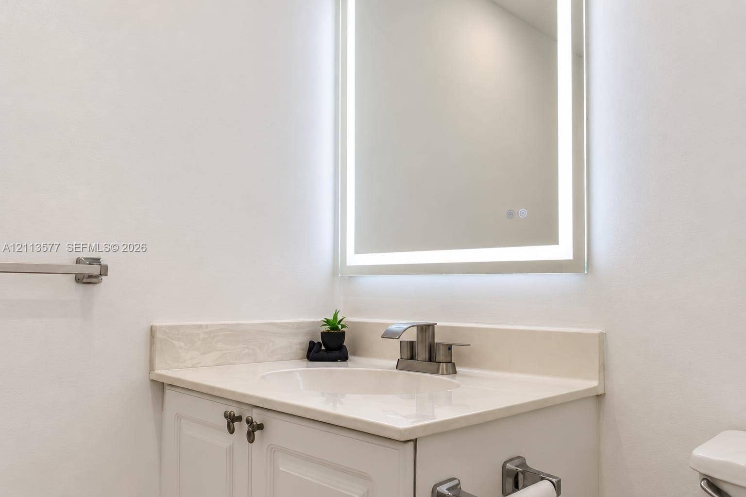 19370 Collins Avenue, #1622, Sunny Isles Beach, FL 33160 Built-in vanity with integrated countertop and sink, brushed metallic faucet, and wall-mounted illuminated mirror