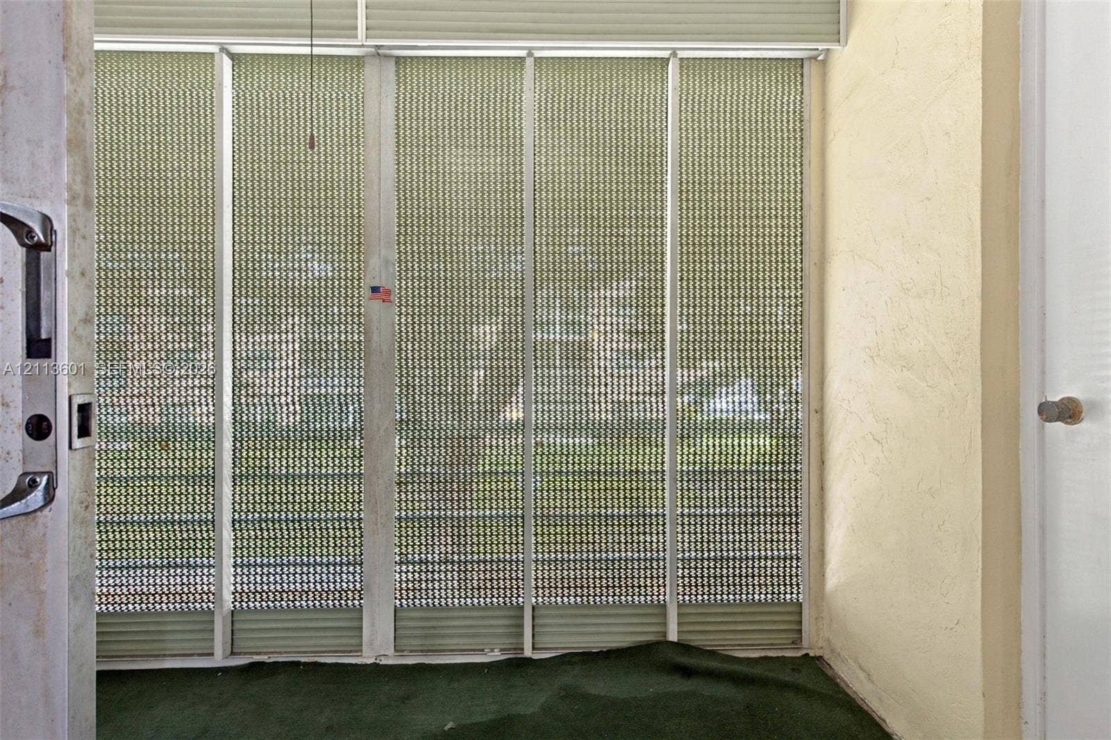 Enclosed porch featuring aluminum framing, integrated metal security screens, and textured wall finishes