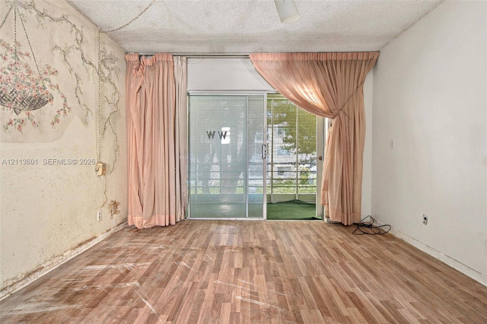 Wood-finish flooring and aluminum-framed sliding glass door providing external access