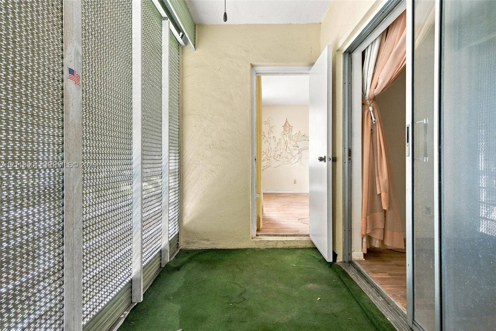 Enclosed porch featuring screen wall panels, textured wall finishes, and sliding glass entry doors