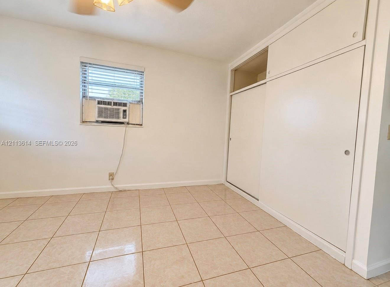 2901 Polk Street, #16, Hollywood, Hollywood, FL 33020 Interior room featuring neutral tile flooring, built-in floor-to-ceiling closet cabinetry, and a window with integrated blinds