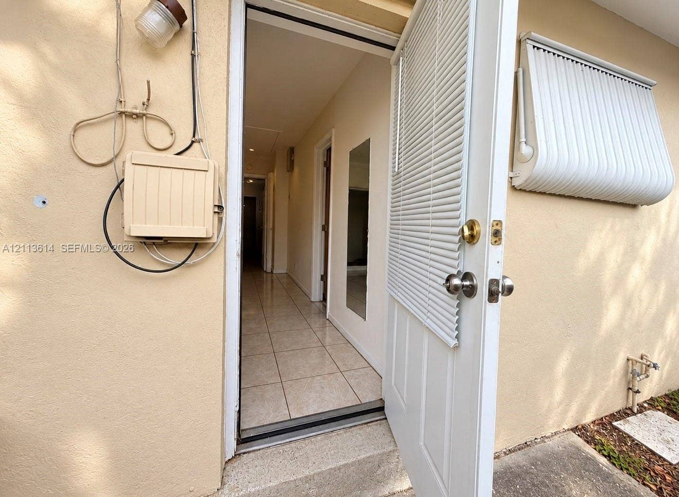 2901 Polk Street, #16, Hollywood, Hollywood, FL 33020 Exterior entry featuring an integrated door blind, a metal window awning, and tile flooring