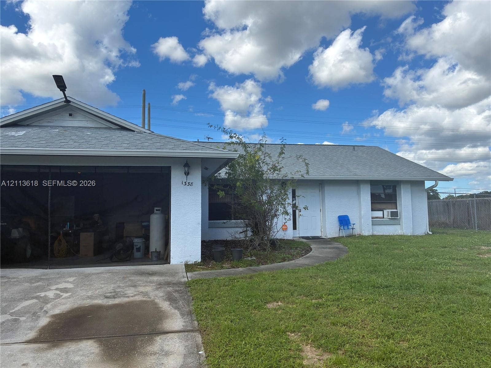 1338 Coral Reef Avenue NW, Palm Bay, FL 32907 Stucco exterior featuring a concrete driveway, attached garage, and asphalt shingle roof
