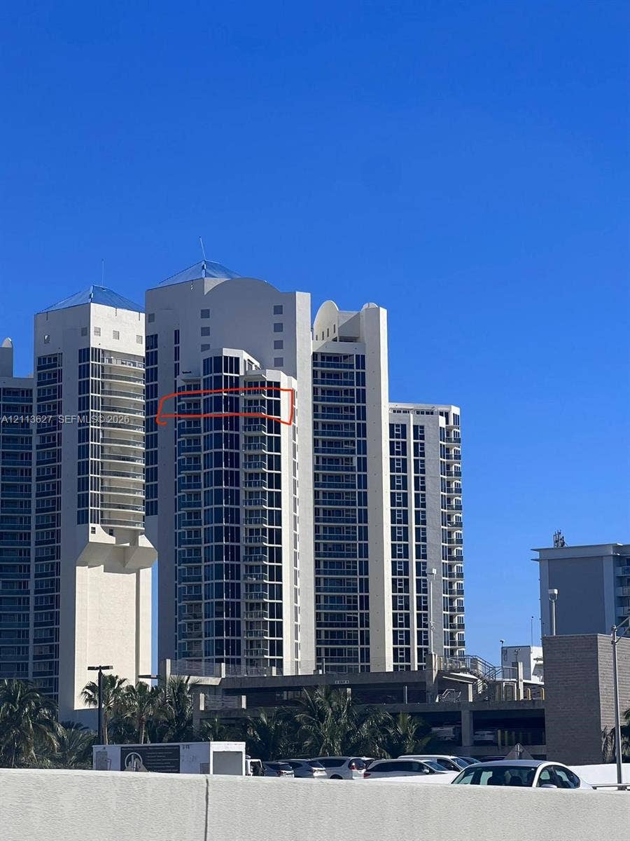 High-rise exterior featuring curved glass facade, stepped architectural design, and private balconies