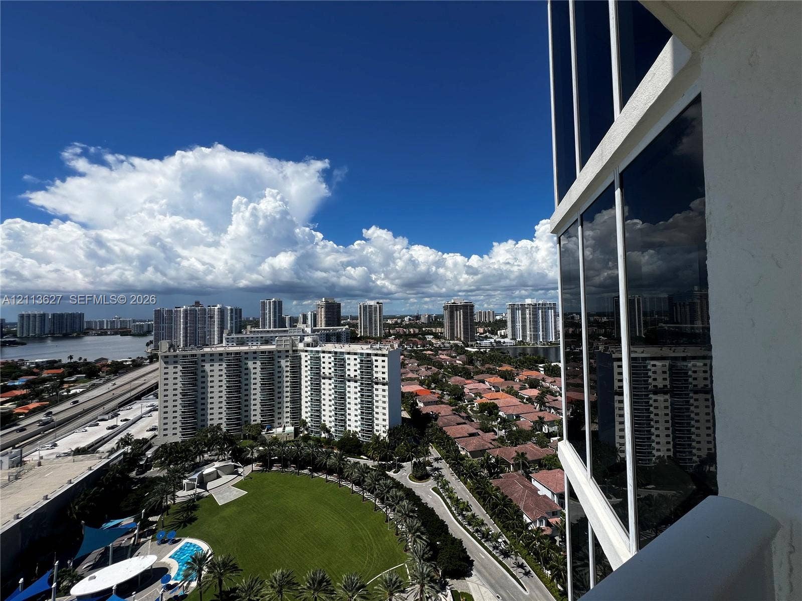 Floor-to-ceiling glass paneling and exterior window wall featuring an expansive perspective of the surrounding cityscape, coastline, and urban infrastructure