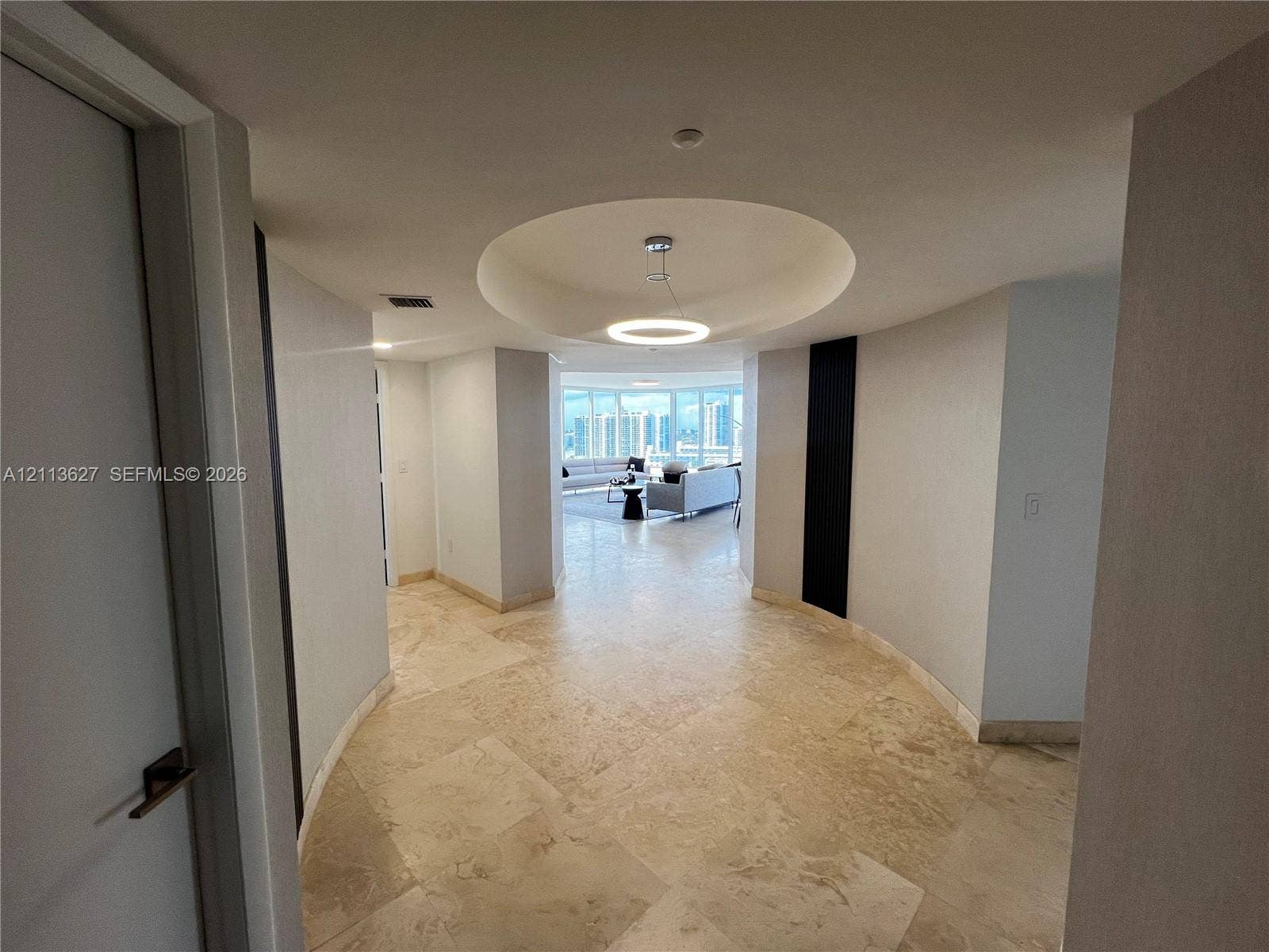 Entryway featuring large-format tile flooring, circular recessed ceiling detail, and integrated lighting fixtures