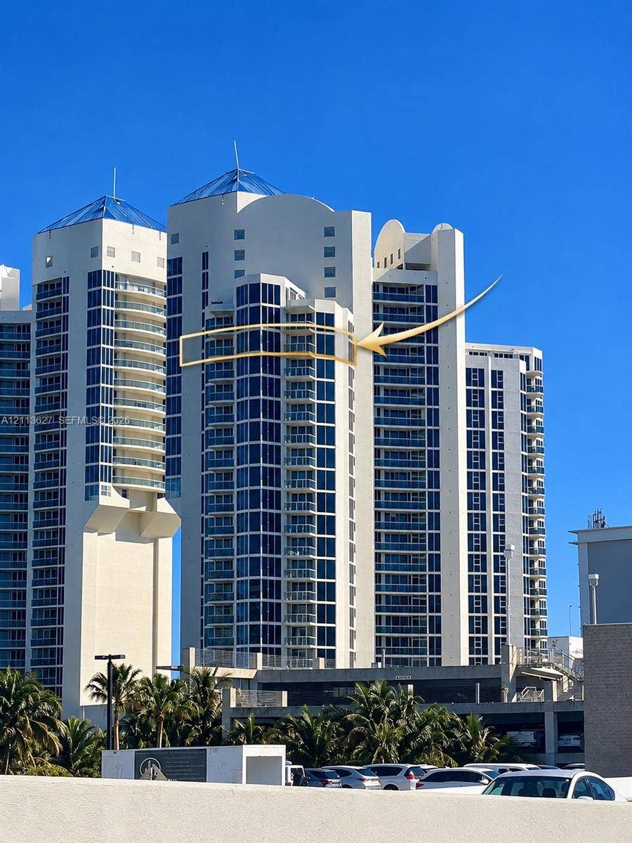 High-rise building featuring white concrete cladding, floor-to-ceiling glass windows, and private balconies