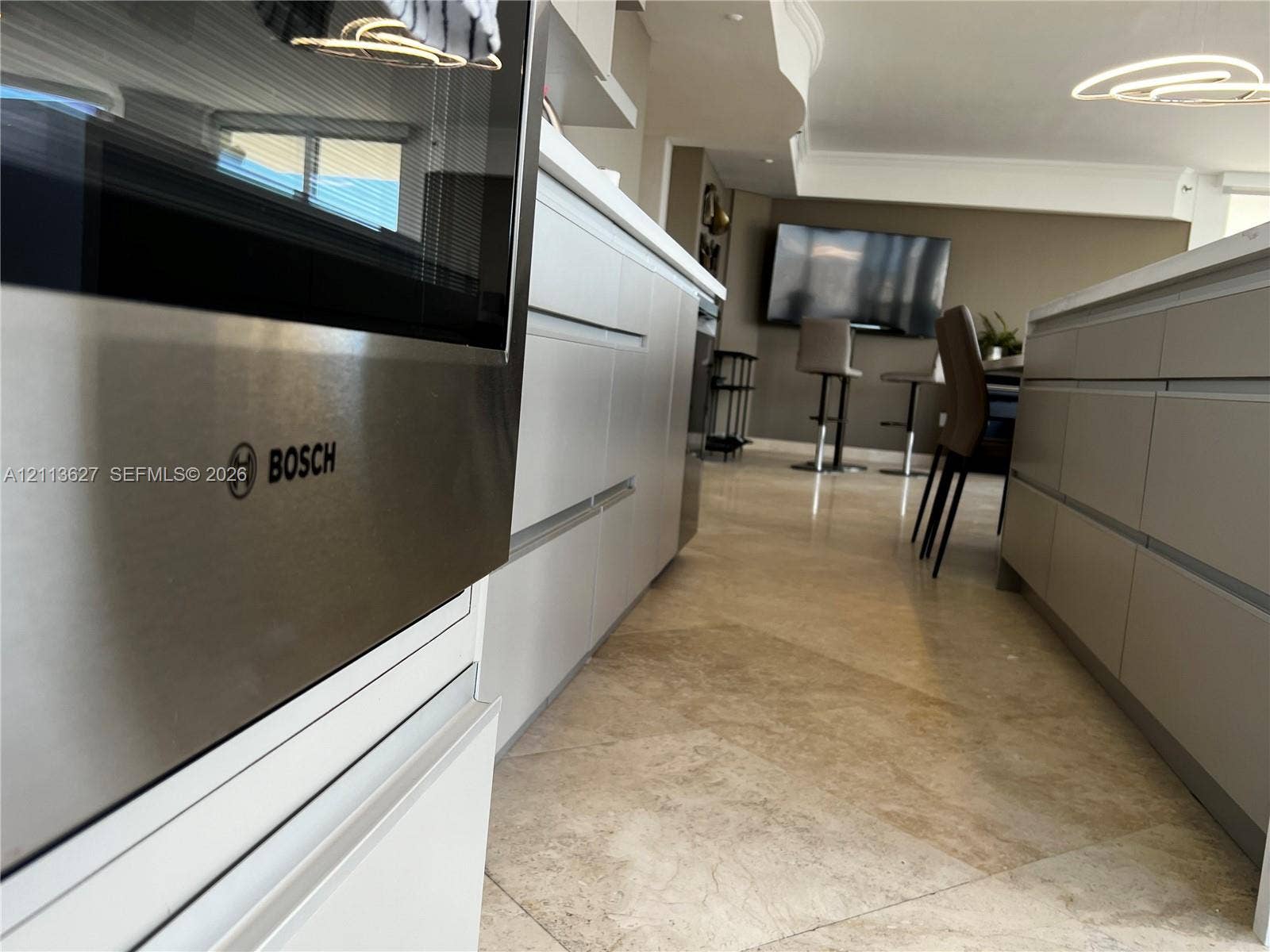 Kitchen featuring stainless steel Bosch wall oven, flat-panel cabinetry, stone-finish countertops, and tile flooring