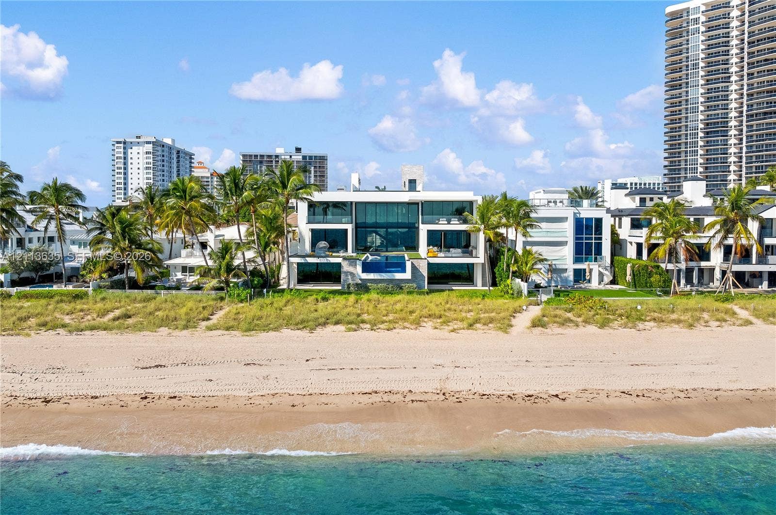 3052 N Atlantic Boulevard, #0, Fort Lauderdale, Fort Lauderdale, FL 33308 Contemporary oceanfront estate featuring floor-to-ceiling glass walls, elevated infinity-edge swimming pool, expansive structural overhangs, and direct beach access