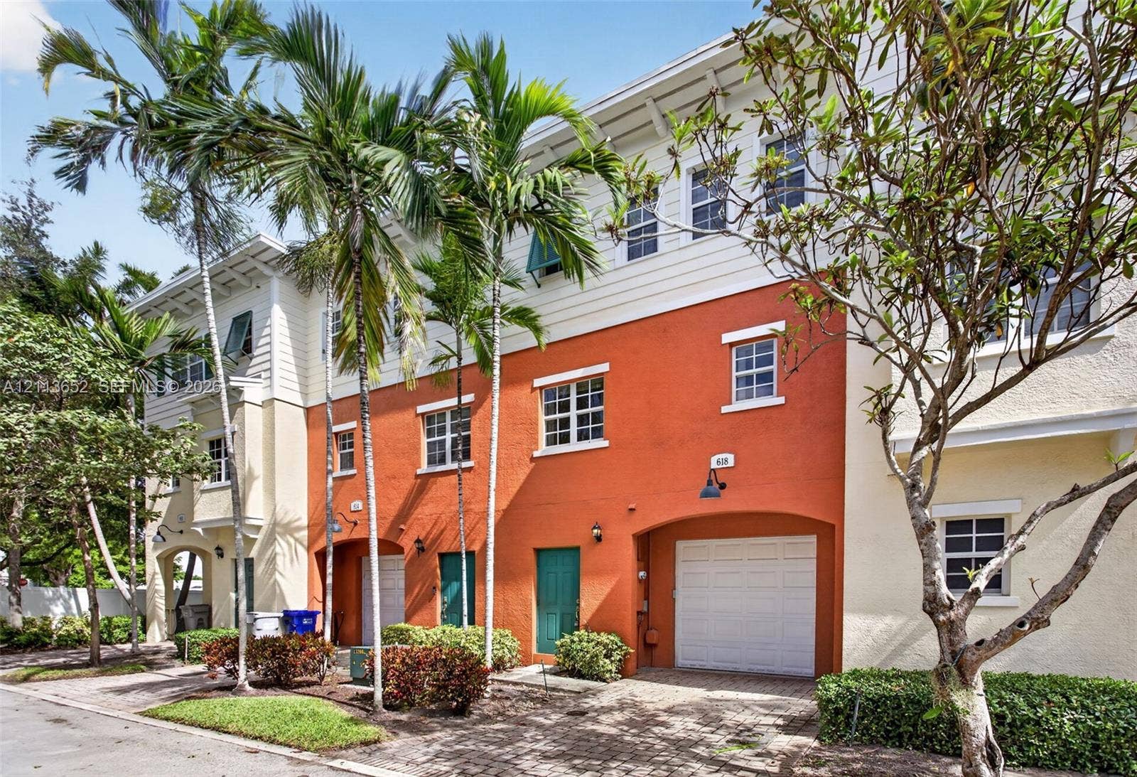618 SW 1st Lane, Pompano Beach, FL 33060 Multi-story exterior featuring a textured stucco facade, integrated single-car garage, brick-paver driveway, and mature landscaping