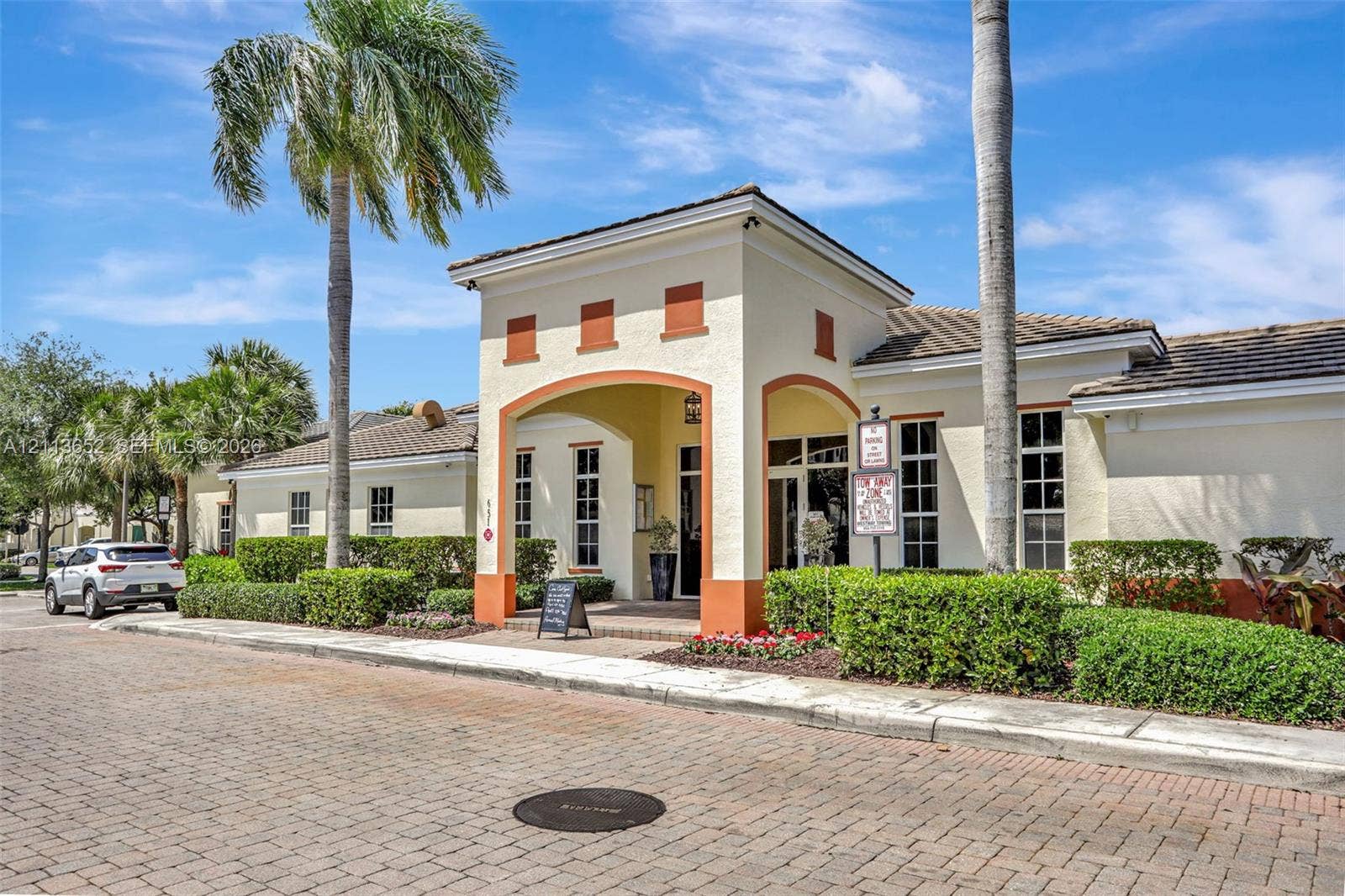 618 SW 1st Lane, Pompano Beach, FL 33060 Stucco exterior featuring an arched entryway, decorative trim, tile roof, and brick-paver street