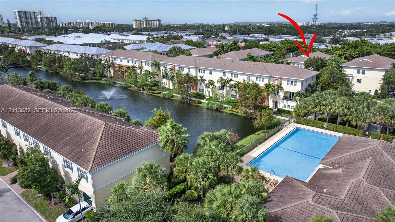 618 SW 1st Lane, Pompano Beach, FL 33060 Aerial perspective featuring waterfront placement, community pool, mature palm landscaping, and tile roofing