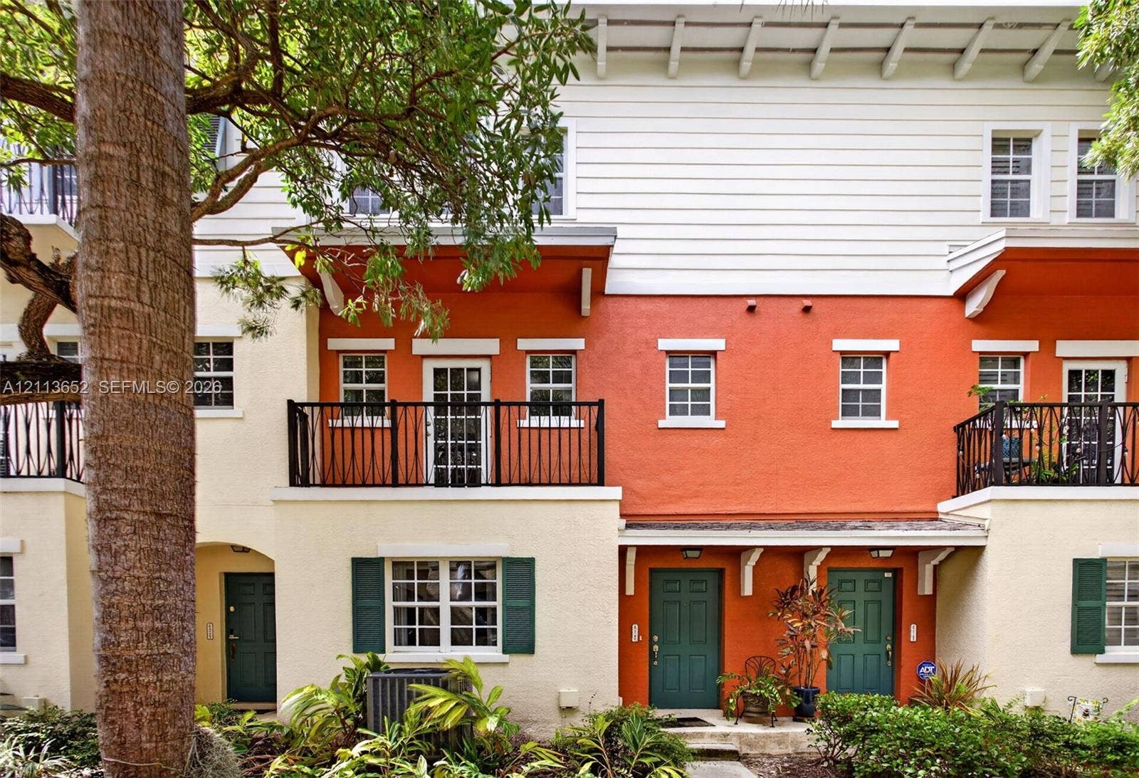 618 SW 1st Lane, Pompano Beach, FL 33060 Multi-level exterior featuring stucco facade, horizontal lap siding, upper-level balconies with metal railings, and decorative wood corbels