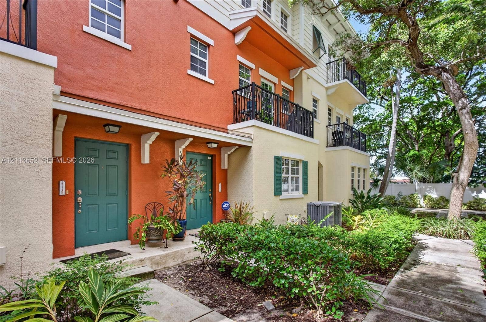 618 SW 1st Lane, Pompano Beach, FL 33060 Multi-level facade featuring stucco exterior, private wrought-iron balconies, louvered shutters, and dual entrance doors