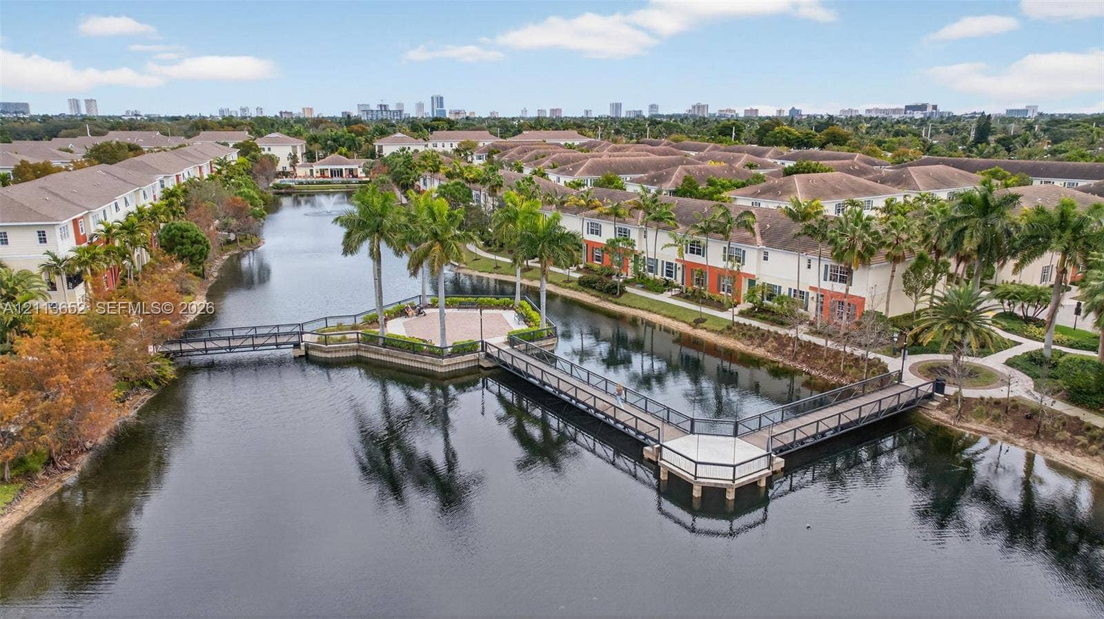 618 SW 1st Lane, Pompano Beach, FL 33060 Community lake featuring pedestrian footbridges, a paved central gazebo, and manicured palm tree landscaping