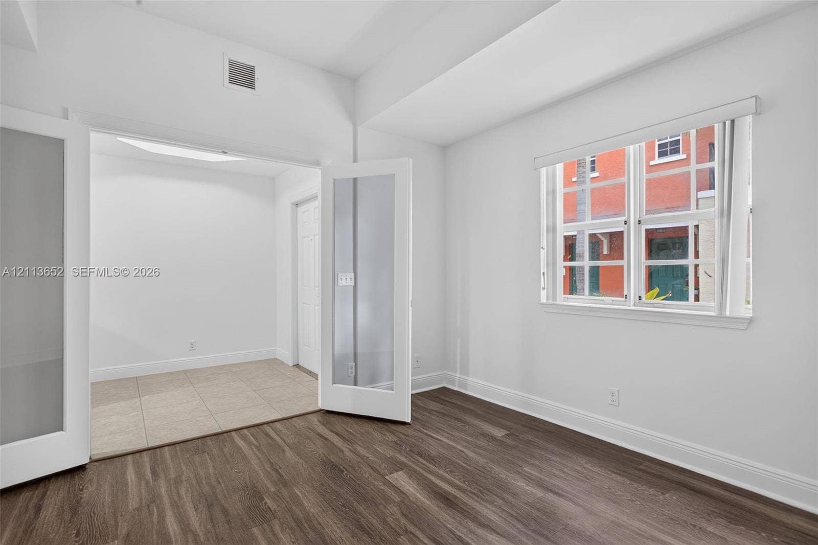 618 SW 1st Lane, Pompano Beach, FL 33060 Room featuring wood-finish flooring, white walls, and a multi-lite window