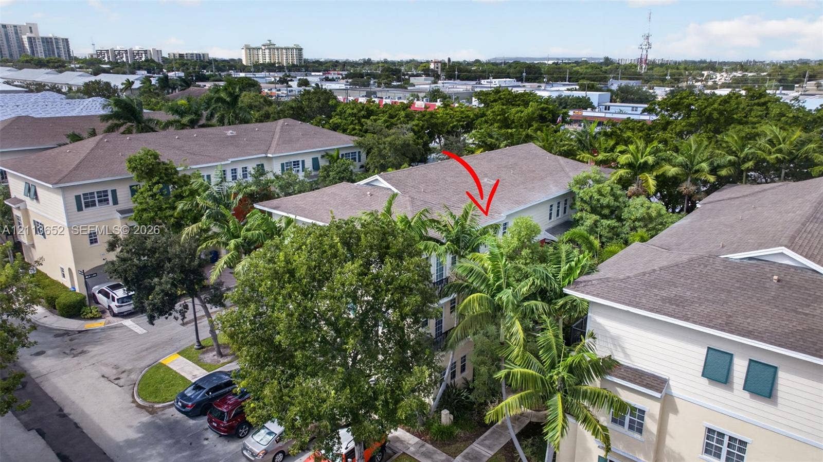 618 SW 1st Lane, Pompano Beach, FL 33060 Aerial perspective of multi-story residence featuring light-toned siding, a pitched roof, and mature palm tree landscaping