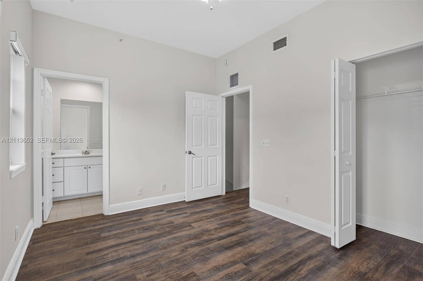 618 SW 1st Lane, Pompano Beach, FL 33060 Interior space featuring wood-finish flooring, six-panel interior doors, and a closet with bifold doors