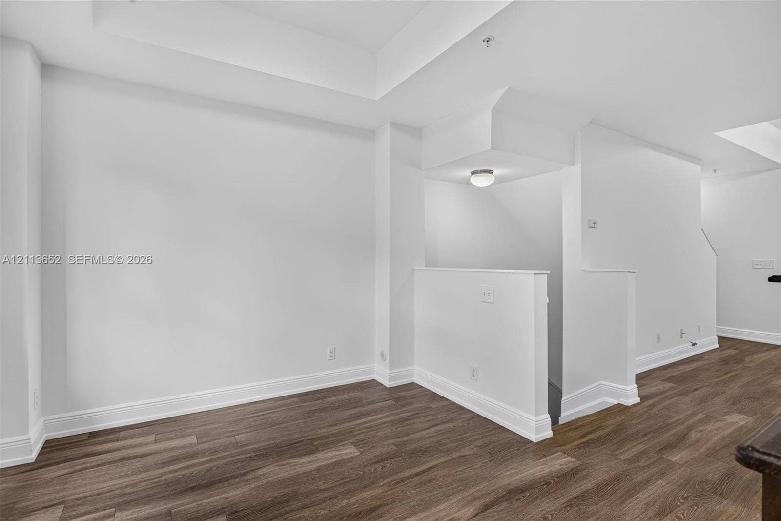 618 SW 1st Lane, Pompano Beach, FL 33060 Interior space featuring wood-finish flooring, tray ceilings, and a flush-mount ceiling light