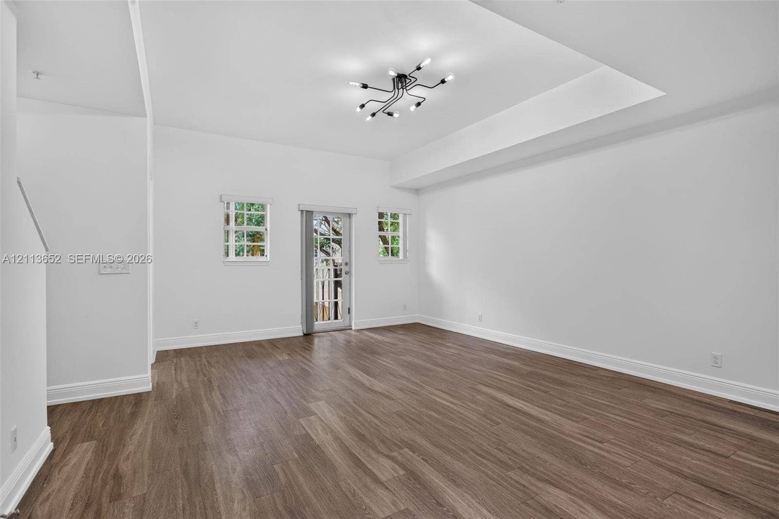 618 SW 1st Lane, Pompano Beach, FL 33060 Tray ceiling, wood-finish flooring, multi-light geometric chandelier, and divided light exterior door