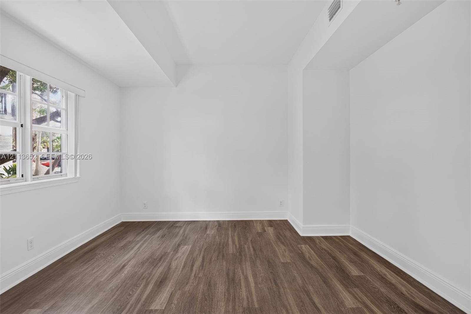 618 SW 1st Lane, Pompano Beach, FL 33060 Room featuring wood-finish flooring, crisp white walls, and a multi-pane window