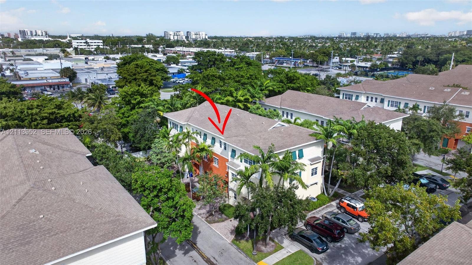 618 SW 1st Lane, Pompano Beach, FL 33060 Multi-story residential building featuring a shingled roof, stucco exterior, shuttered windows, and mature palm trees