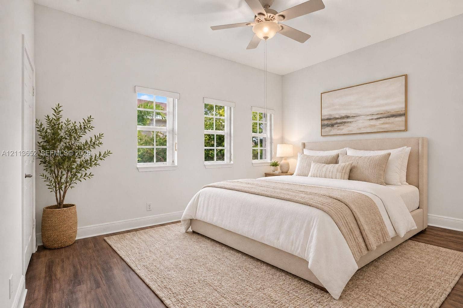 618 SW 1st Lane, Pompano Beach, FL 33060 Room with wood-finish flooring, high ceilings, three multi-pane windows, and a central ceiling fan with integrated lighting