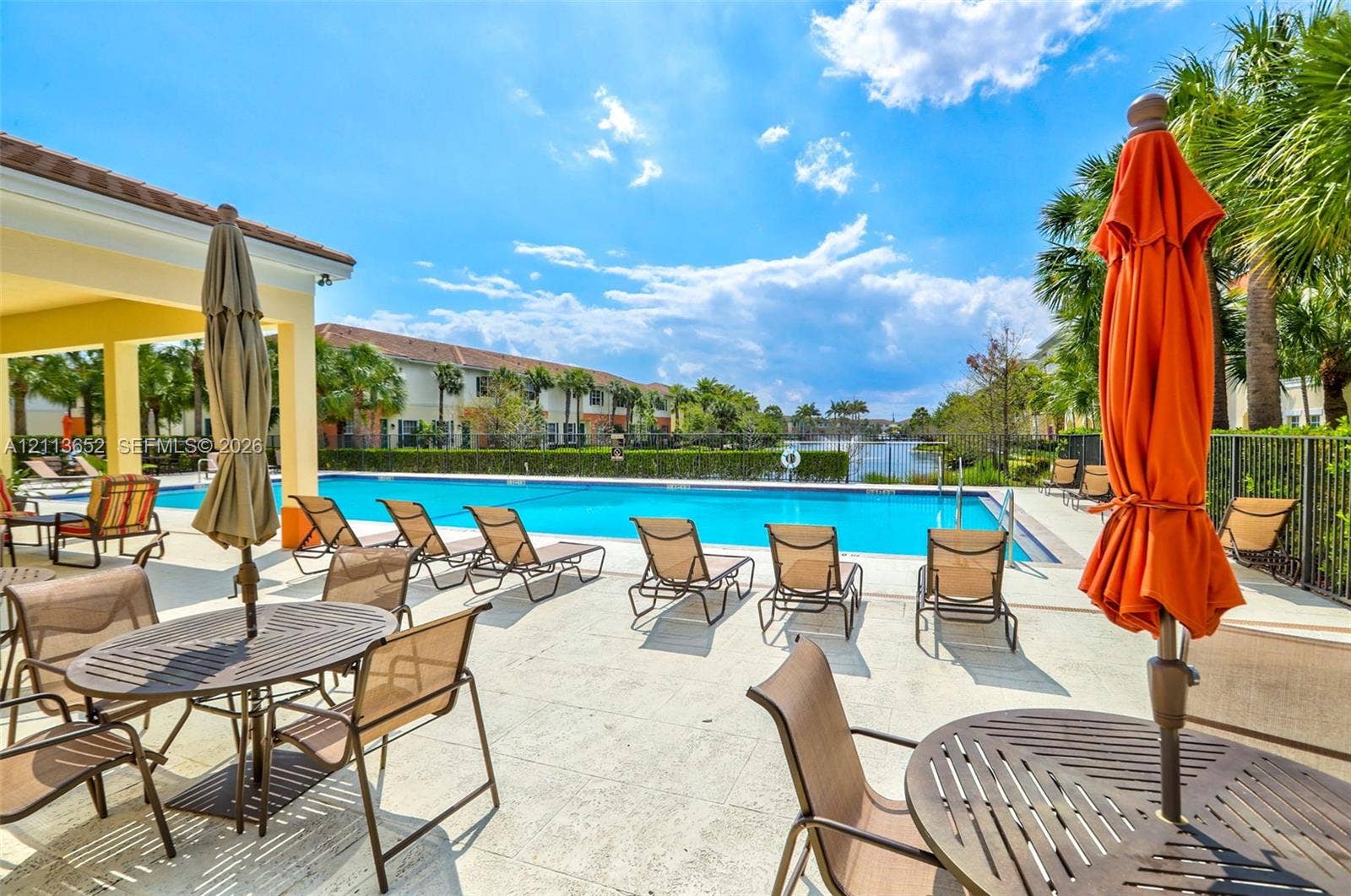 618 SW 1st Lane, Pompano Beach, FL 33060 Community swimming pool featuring a concrete deck, covered patio area, metal fencing, and water frontage