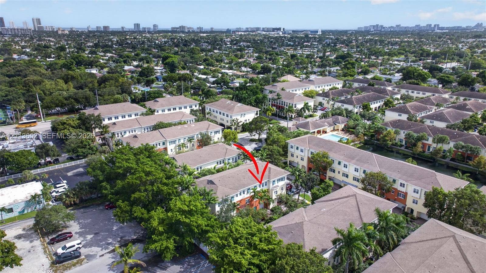 618 SW 1st Lane, Pompano Beach, FL 33060 Aerial perspective of a multi-story residential building featuring a pitched roof, light-toned siding, and mature landscaping