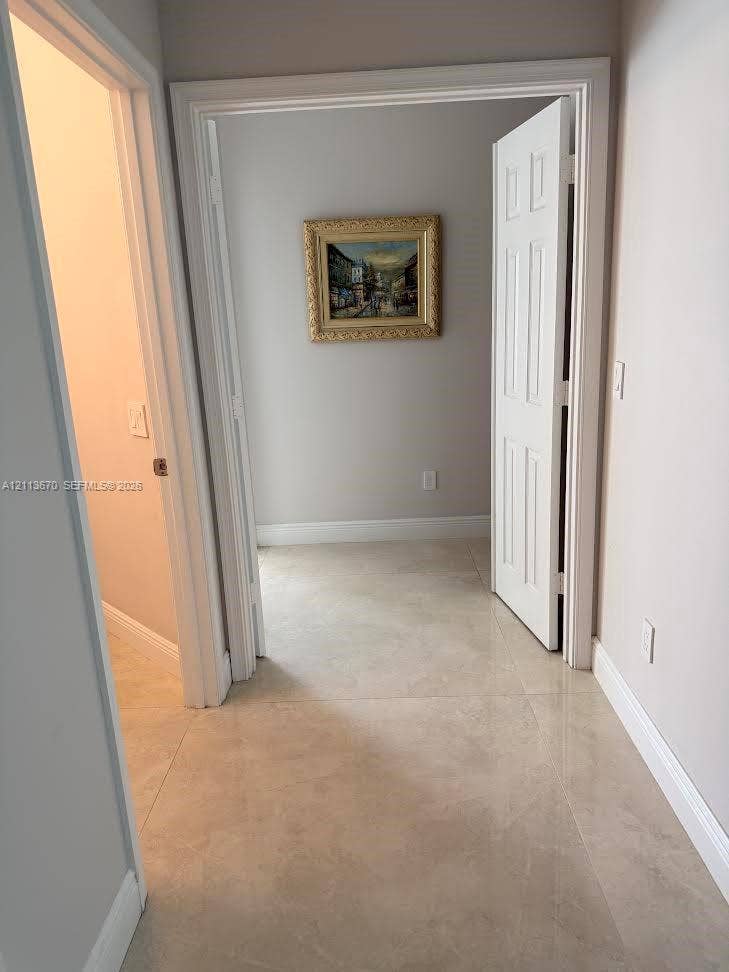 Neutral-toned tile flooring, six-panel interior doors, and neutral wall paint