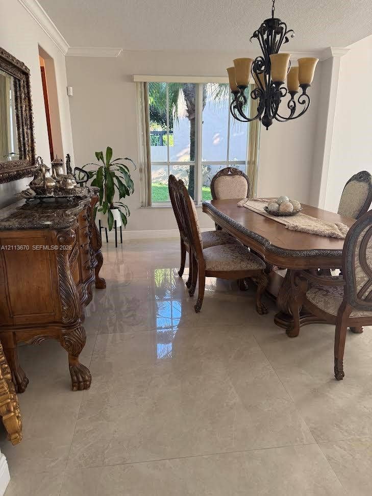 Large-format polished tile flooring, decorative wrought-iron chandelier, and multi-pane window with crown molding