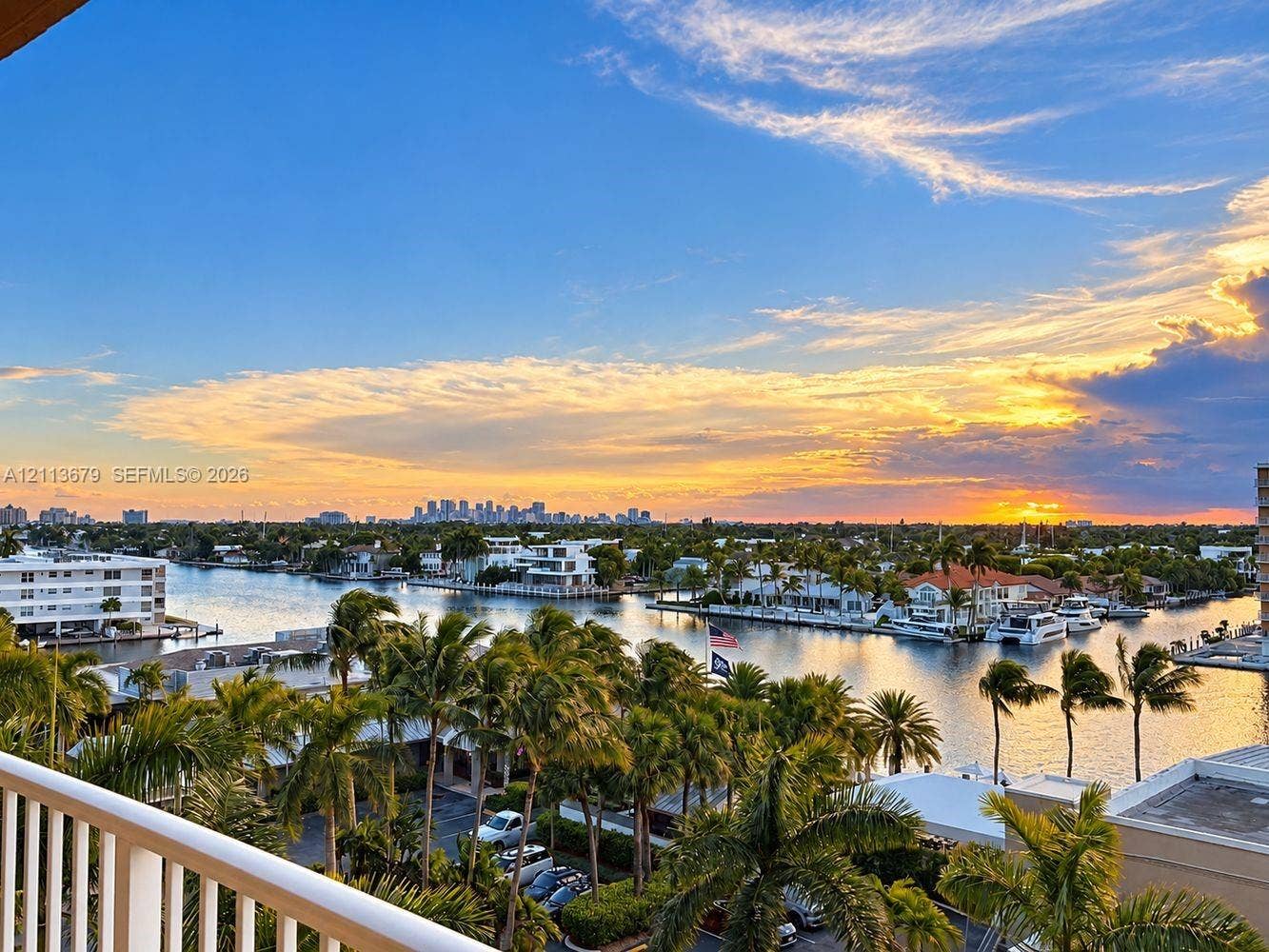 3020 NE 32nd Avenue, #612, Fort Lauderdale, Fort Lauderdale, FL 33308 Elevated balcony featuring a white railing, overlooking a waterway with mature palm trees and a distant urban skyline