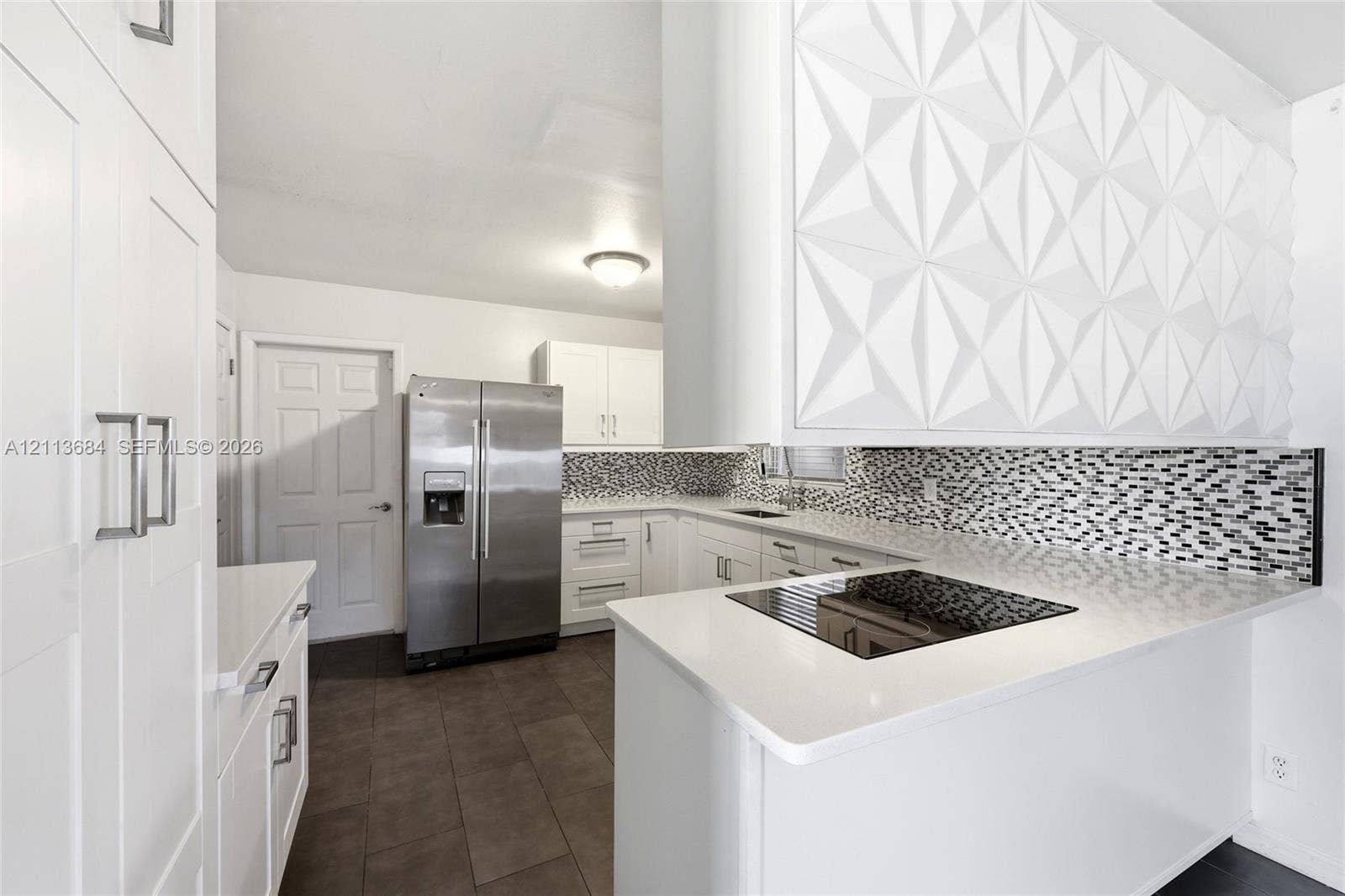 6504 Lenore Drive, Tampa, Tampa, FL 33634 Kitchen featuring white Shaker-style cabinetry, a textured geometric-patterned soffit, stone-surface countertops, a mosaic tile backsplash, and stainless steel appliances