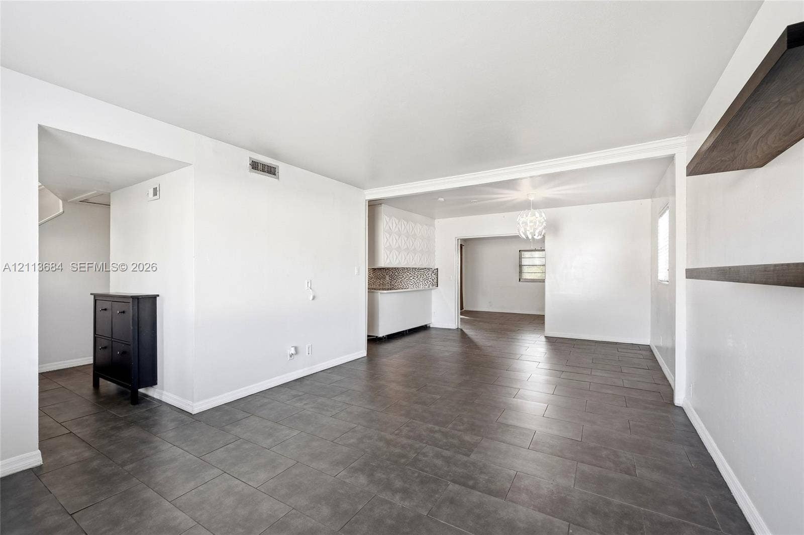 6504 Lenore Drive, Tampa, Tampa, FL 33634 Large-format neutral floor tiling, built-in wall shelving, recessed overhead lighting, and white cabinetry