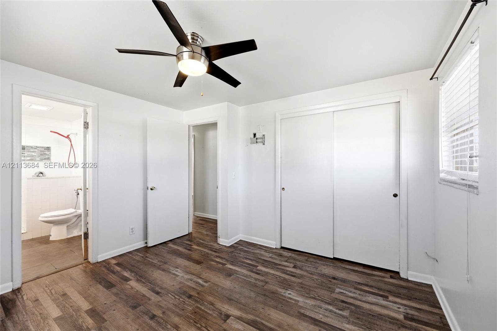 6504 Lenore Drive, Tampa, Tampa, FL 33634 Wood-finish flooring, brushed nickel ceiling fan with integrated lighting, and dual-panel sliding closet doors