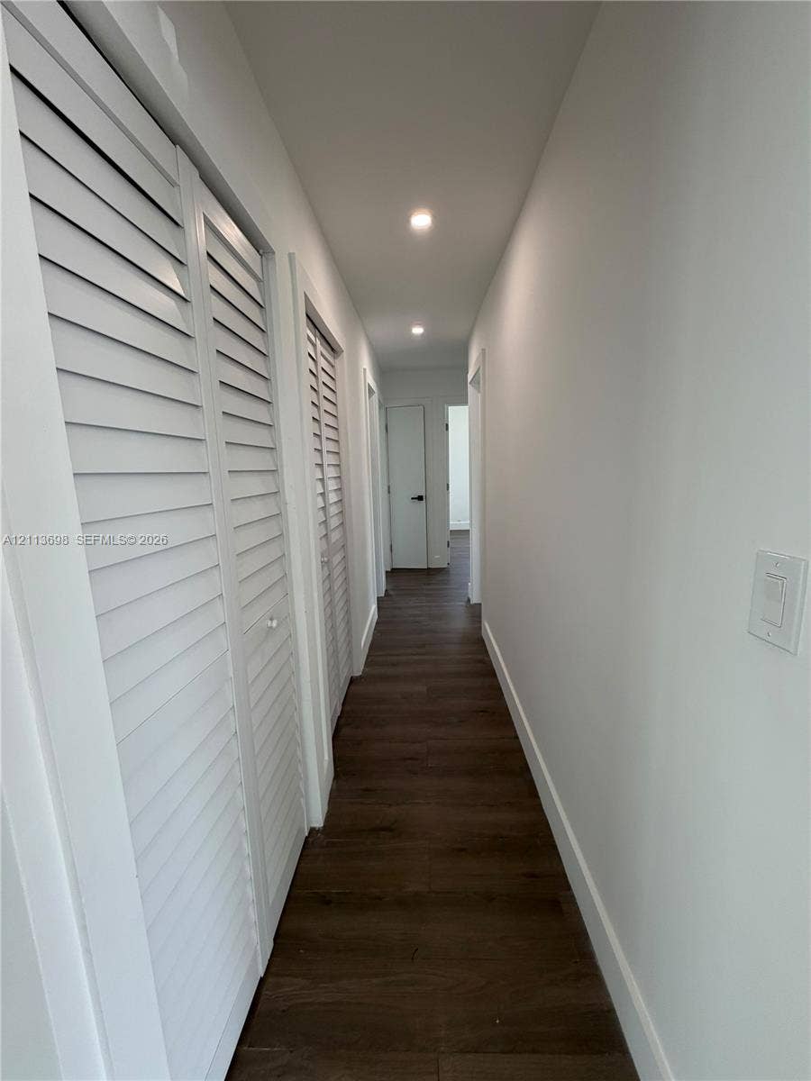 115 NE 205th Terrace, Miami Gardens, FL 33179 Hallway featuring wood-finish flooring, recessed lighting, and white louvered closet doors