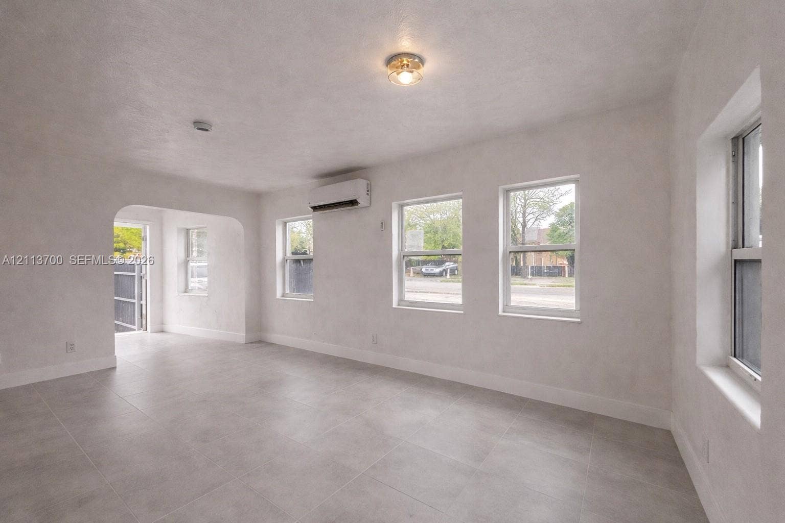 2707 Lincoln Street, #17-18, Hollywood, Hollywood, FL 33020 Neutral-toned tile flooring, smooth-finish walls, arched threshold, dual-pane windows, and wall-mounted climate control unit