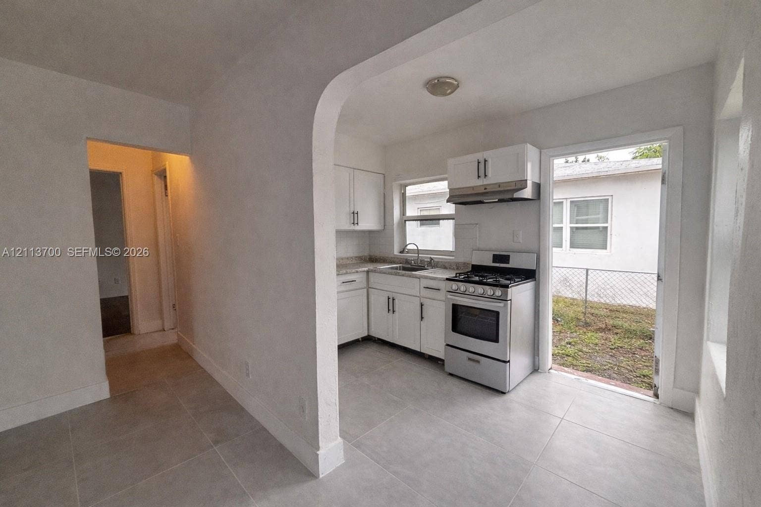 2707 Lincoln Street, #17-18, Hollywood, Hollywood, FL 33020 Kitchen featuring white cabinetry, stone-finish countertops, tile flooring, and a stainless steel gas range with an integrated vent hood
