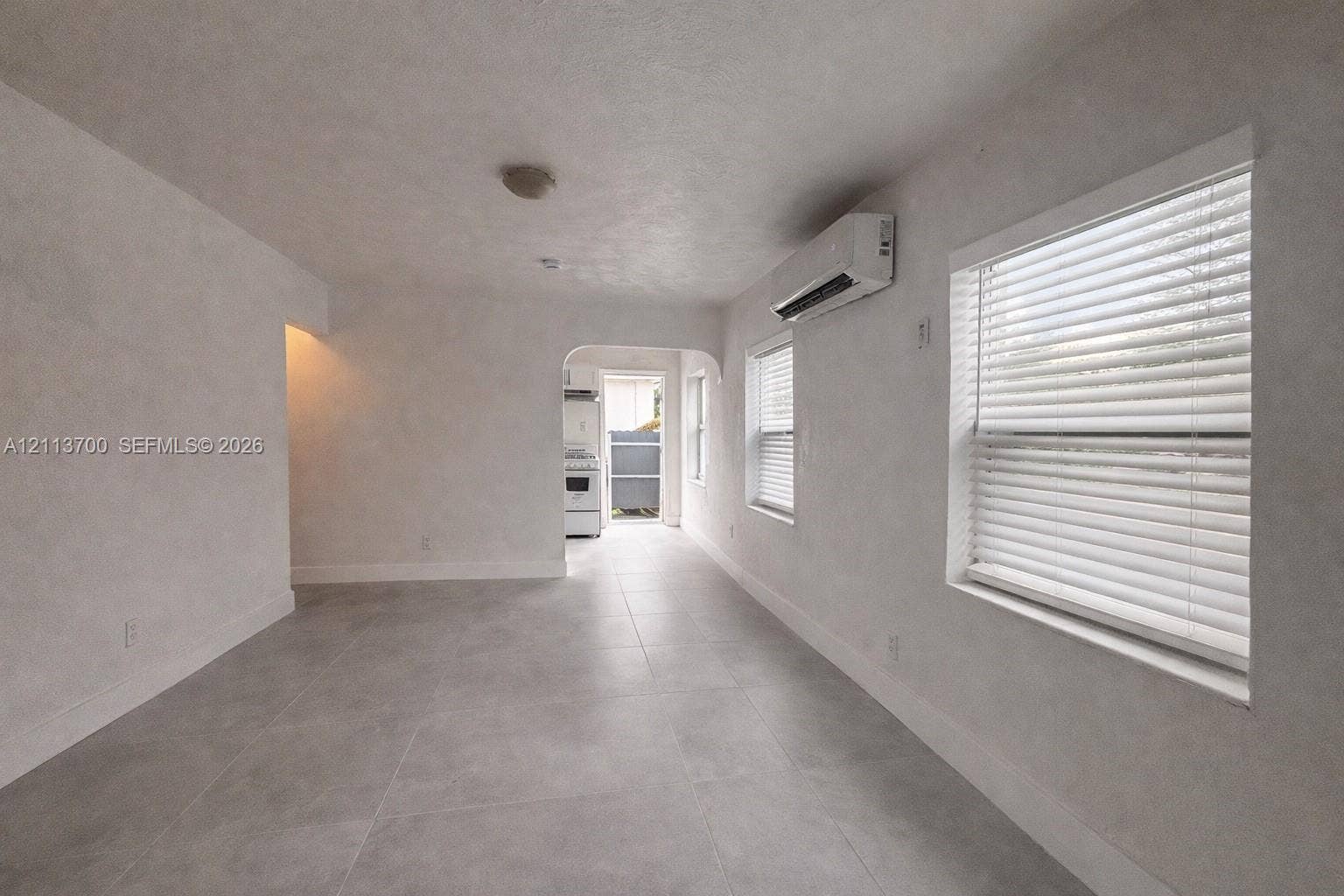 2707 Lincoln Street, #17-18, Hollywood, Hollywood, FL 33020 Neutral-toned tile flooring, recessed ceiling lighting, wall-mounted ductless heating and cooling unit, and dual windows with horizontal blinds