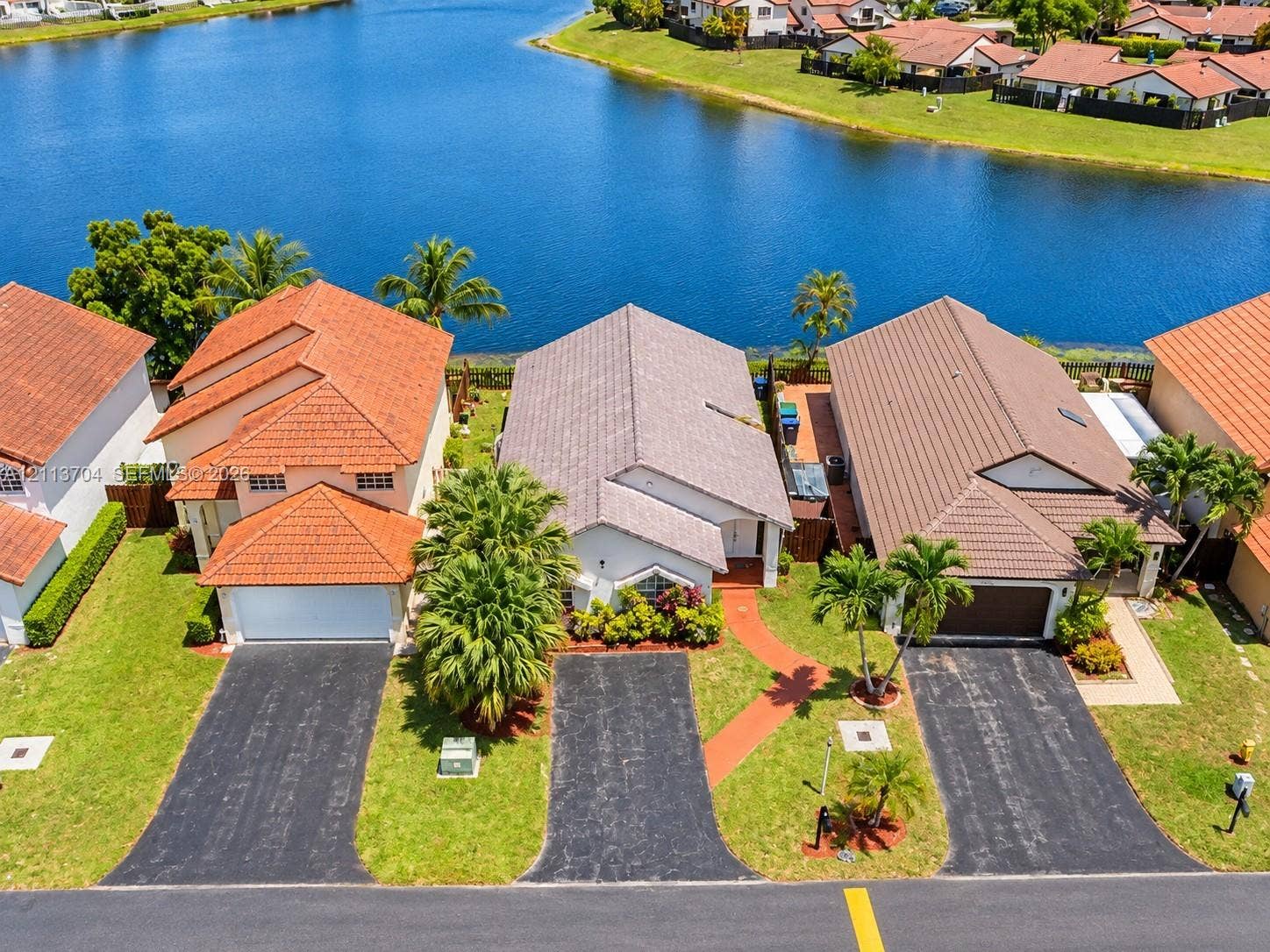 5254 SW 153rd Court, Miami, FL 33185 Waterfront residential properties featuring tile roofing, paved driveways, and mature landscaping