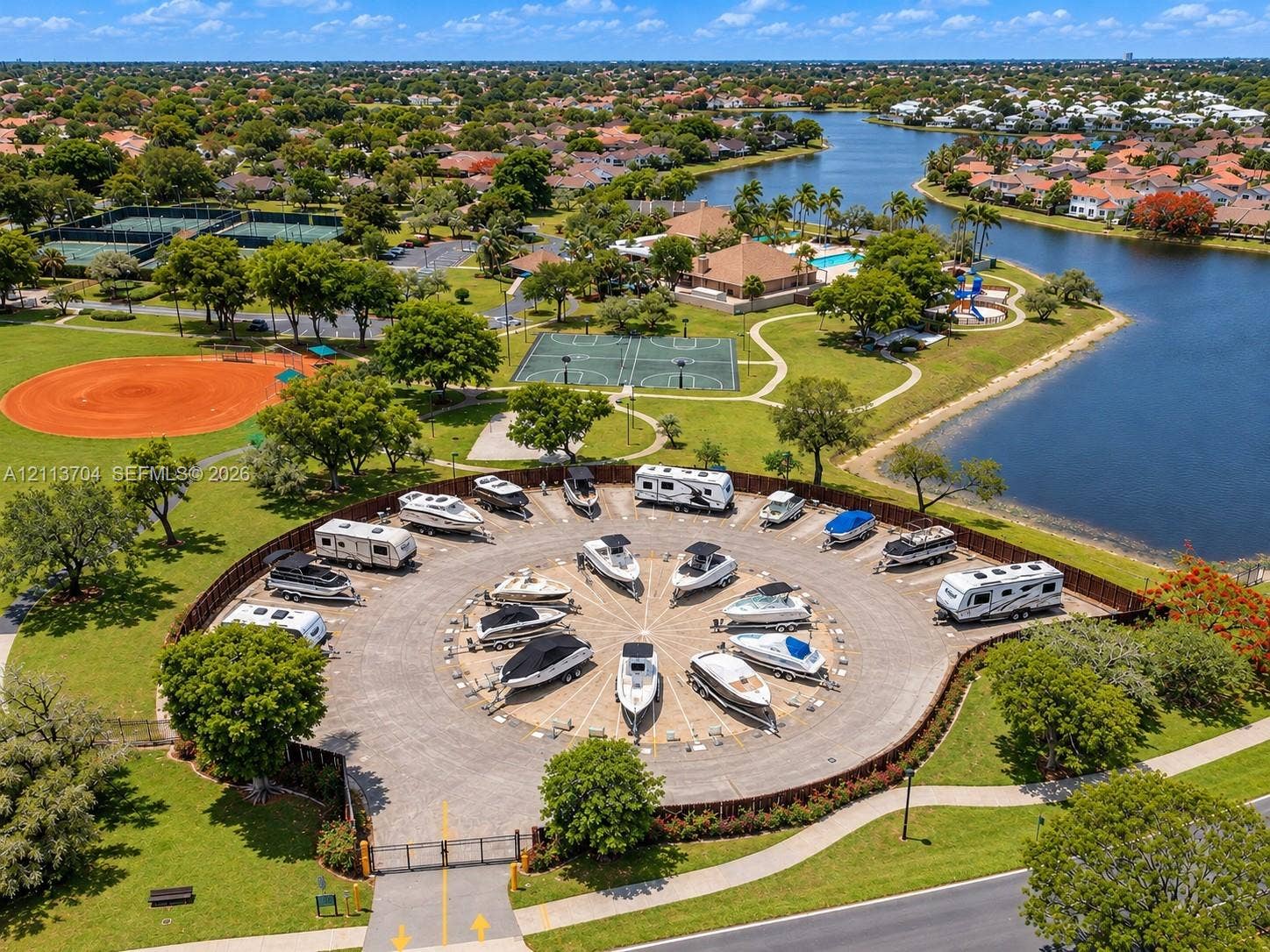 5254 SW 153rd Court, Miami, FL 33185 Gated circular storage area featuring paved parking pads for watercraft and recreational vehicles, enclosed by perimeter fencing