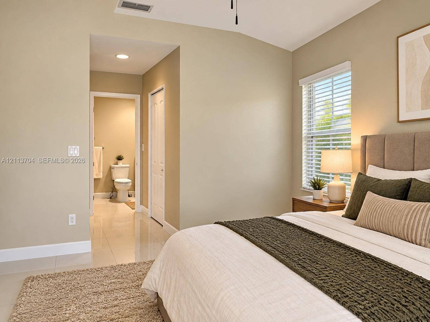 5254 SW 153rd Court, Miami, FL 33185 Neutral-toned room featuring high-gloss tile flooring, vaulted ceiling, and window with built-in blinds