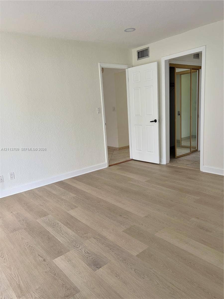 5170 SW 40th Avenue, #1E, Dania, Dania Beach, FL 33314 Wood-finish flooring, six-panel interior doors, and mirrored closet doors
