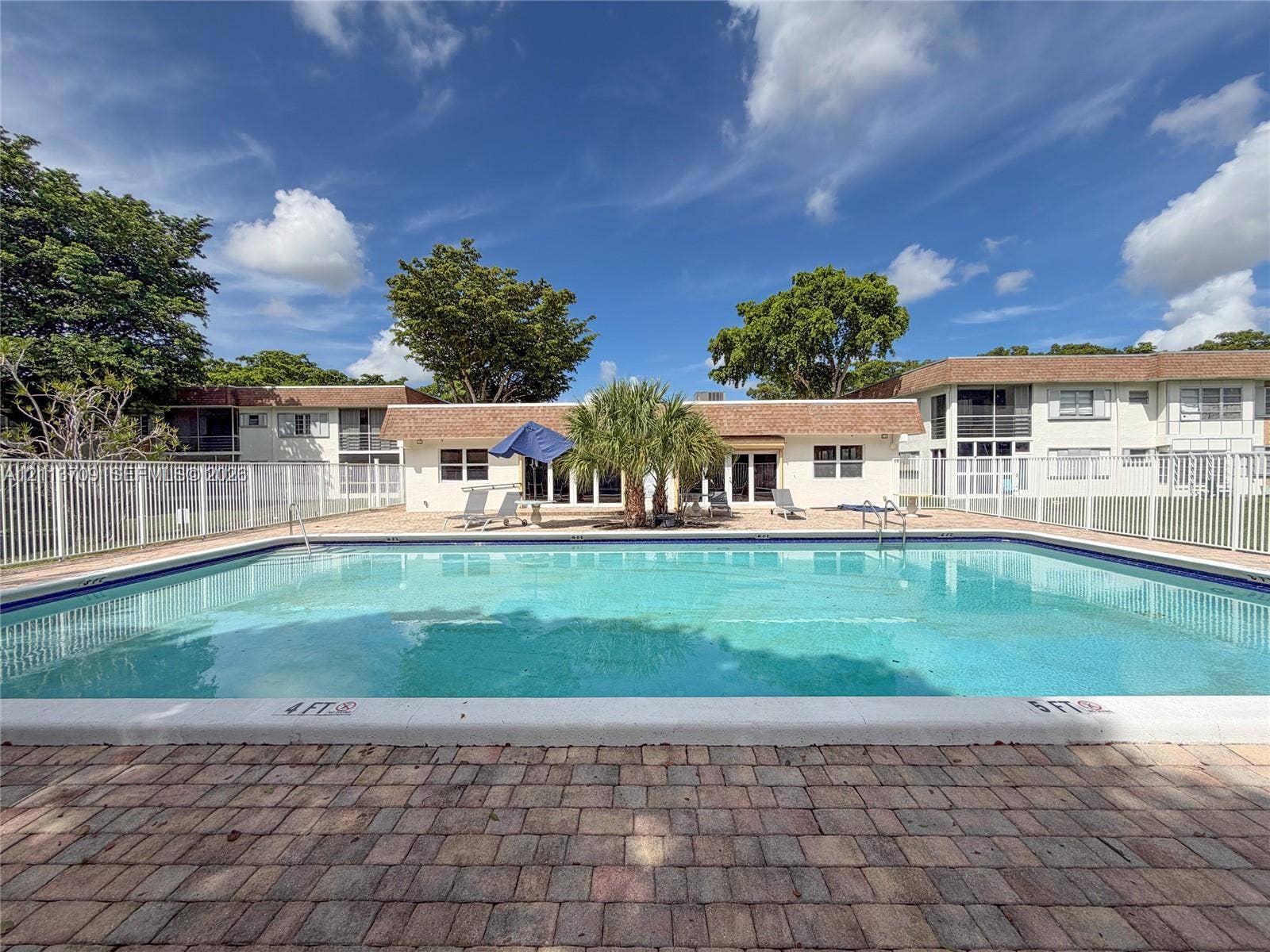 5170 SW 40th Avenue, #1E, Dania, Dania Beach, FL 33314 In-ground swimming pool featuring a brick paver deck and white metal fencing
