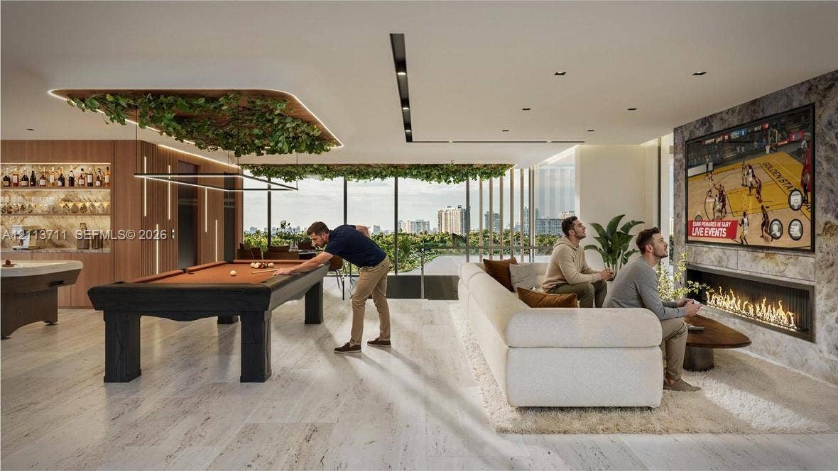 3322 NE 16th Court, Fort Lauderdale, FL 33305 Stone flooring, linear gas fireplace with stone surround, recessed ceiling lighting, and floor-to-ceiling glass windows