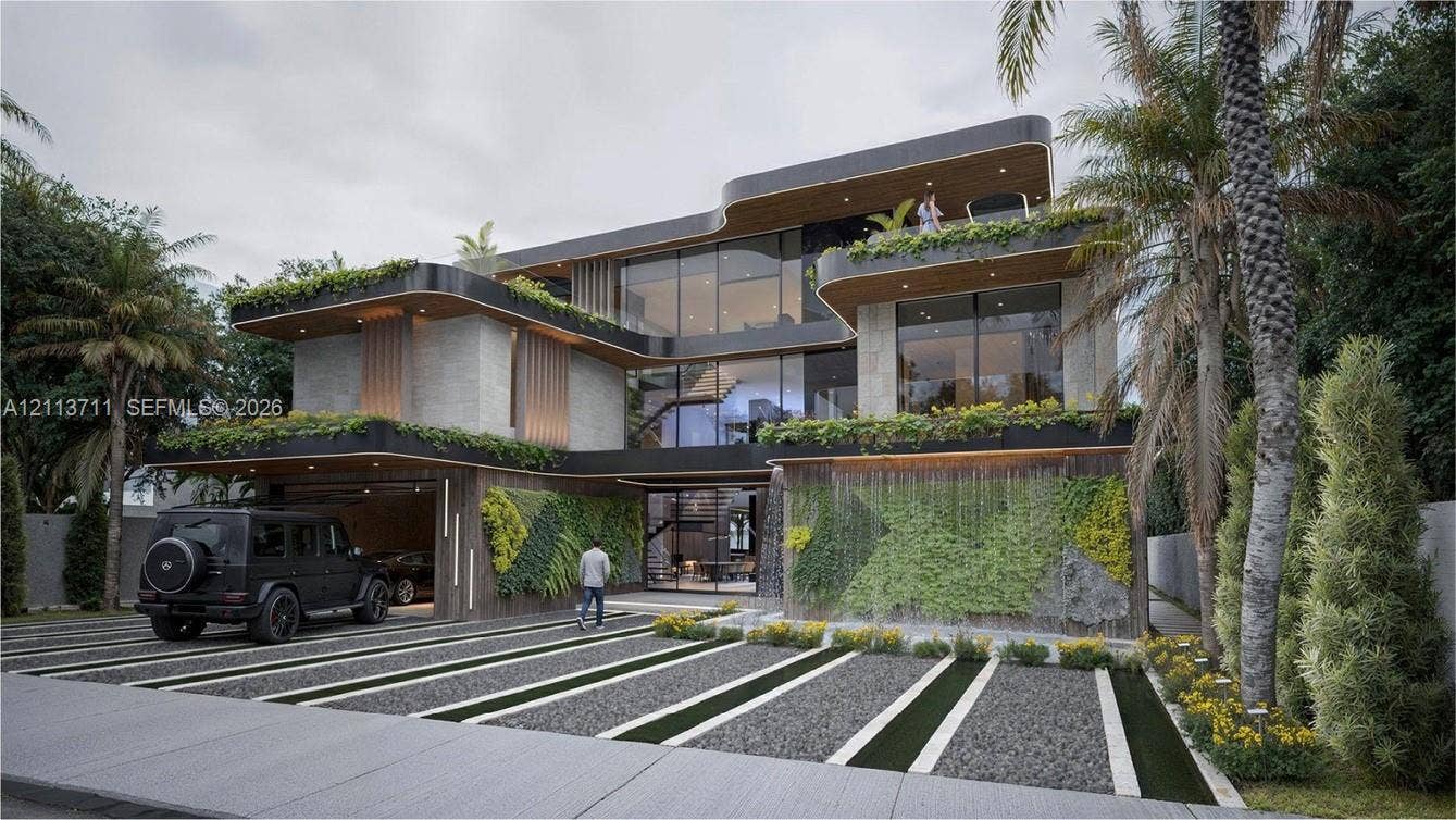 3322 NE 16th Court, Fort Lauderdale, FL 33305 Contemporary three-story residence featuring expansive floor-to-ceiling glass paneling, integrated vertical garden walls, multi-level cantilevered balconies, and a built-in cascading water feature