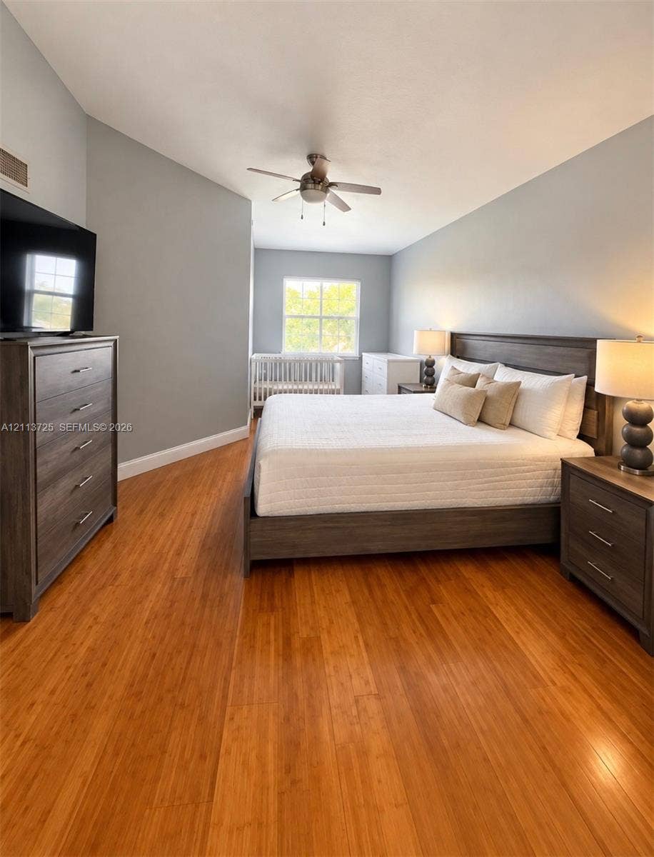 Room featuring wood-finish flooring, vaulted ceiling, and a ceiling fan