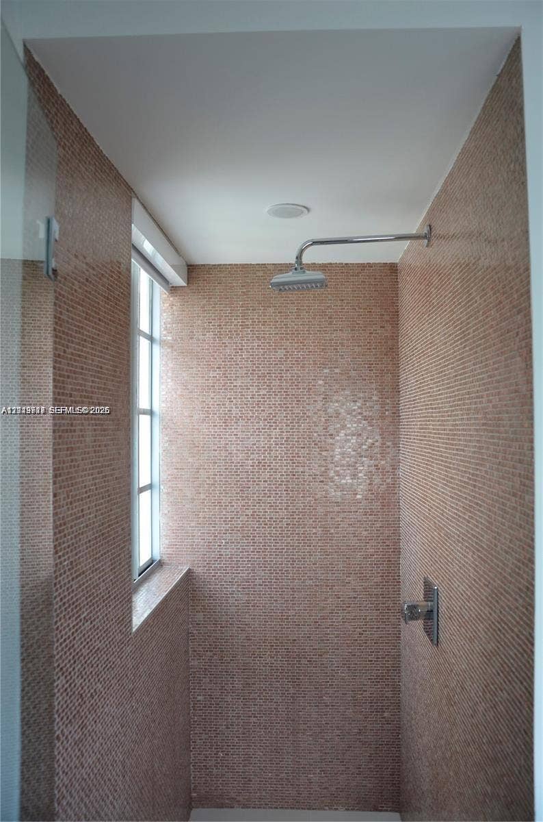 700 SE 16th Street, #201, Miami Beach, Miami Beach, FL 33139 Shower stall featuring floor-to-ceiling mosaic tile, wall-mounted rainfall showerhead, single-handle pressure balance valve, and a window with a glass pane