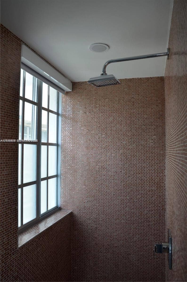 700 SE 16th Street, #201, Miami Beach, Miami Beach, FL 33139 Shower enclosure featuring floor-to-ceiling mosaic tile, a grid-pane window with a stone sill, and a polished chrome rainfall shower head
